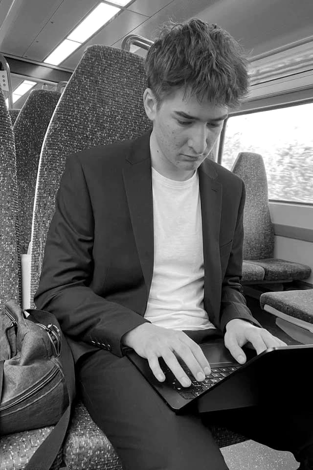 Jan Štok typing on a laptop on a train